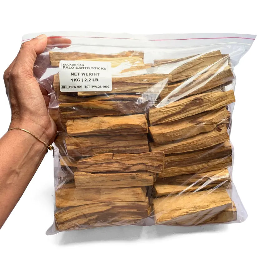 Hands arranging wholesale Palo Santo powder and sticks — packaging process for export or private label