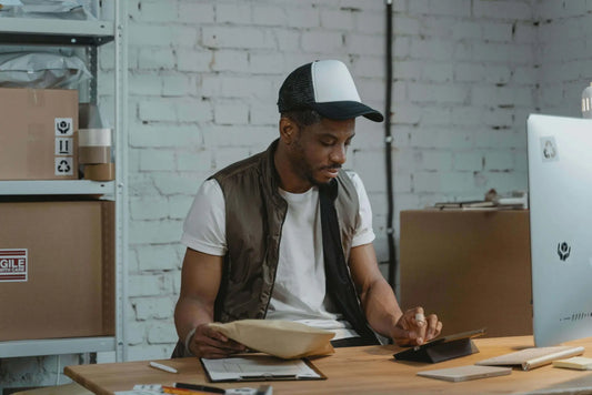 Smart importer managing Palo Santo bulk orders in warehouse office.