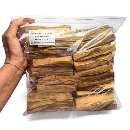 Hands arranging wholesale Palo Santo powder and sticks — packaging process for export or private label
